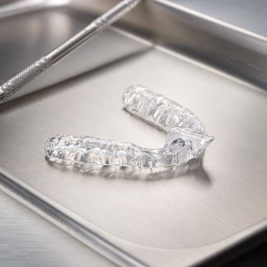 Clear nightguard for bruxism treatment on metal tray