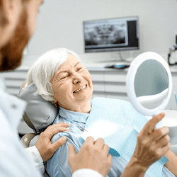 a patient admiring her new dental implants in Shelton
