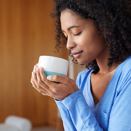 Woman drinking a cup of coffee which can cause tooth staining